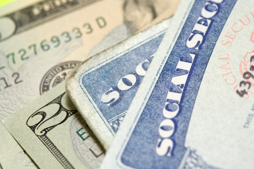 Social Security cards on top of cash