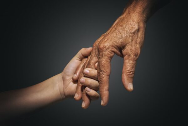 Close up of elderly hand holding a child's hand