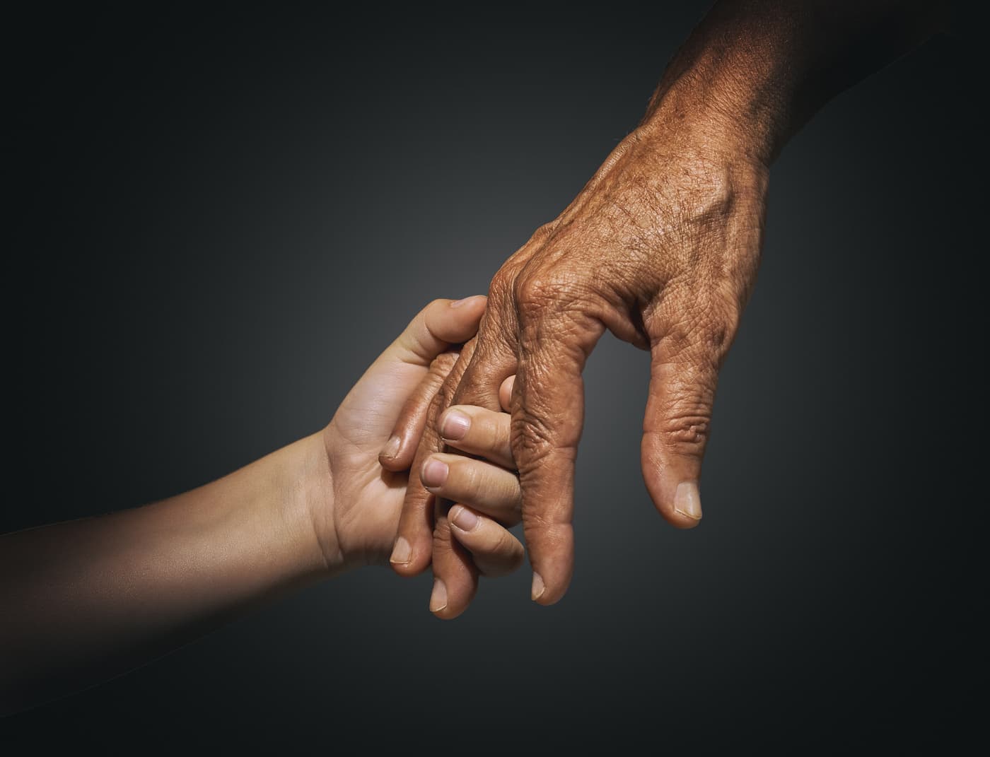 Close up of elderly hand holding a child's hand