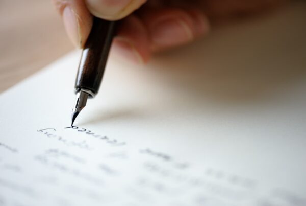 Close up of hand writing a letter with pen