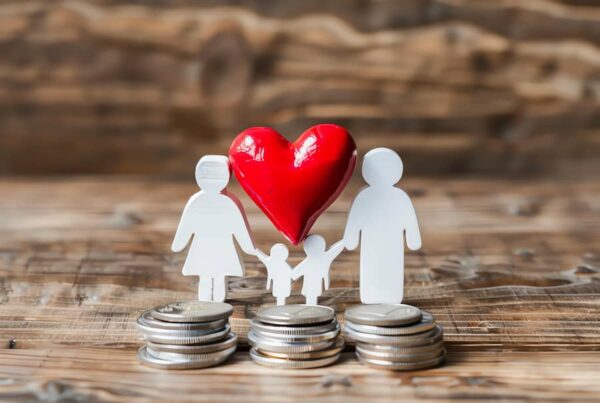 An outline of a family with a red heart and coins